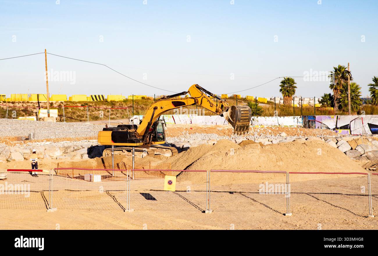 Sito industriale con escavatore e operaio edile. Barcellona Spagna 27.10.2025 Foto Stock