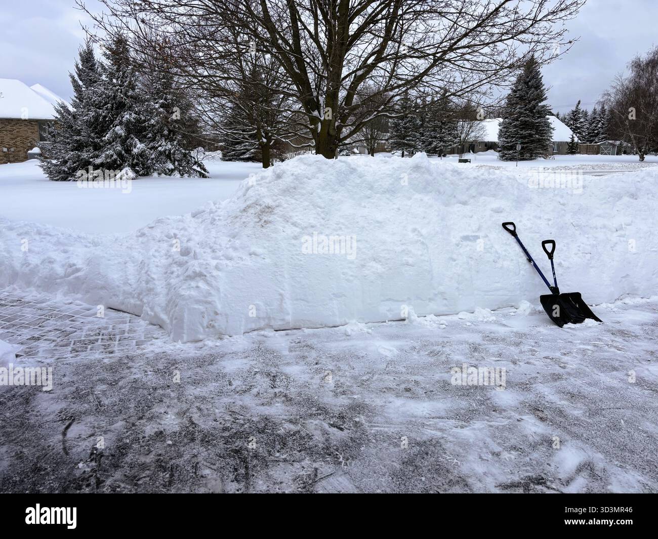 Ha finito di spalare e scavare un vialetto dopo una grande tempesta di neve nel sud dell'Ontario, Canada Foto Stock