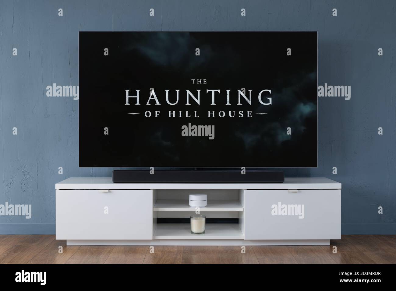 Un televisore OLED widescreen che mostra un trailer della serie TV The Haunting of Hill House, visto in un salotto contemporaneo. Foto Stock