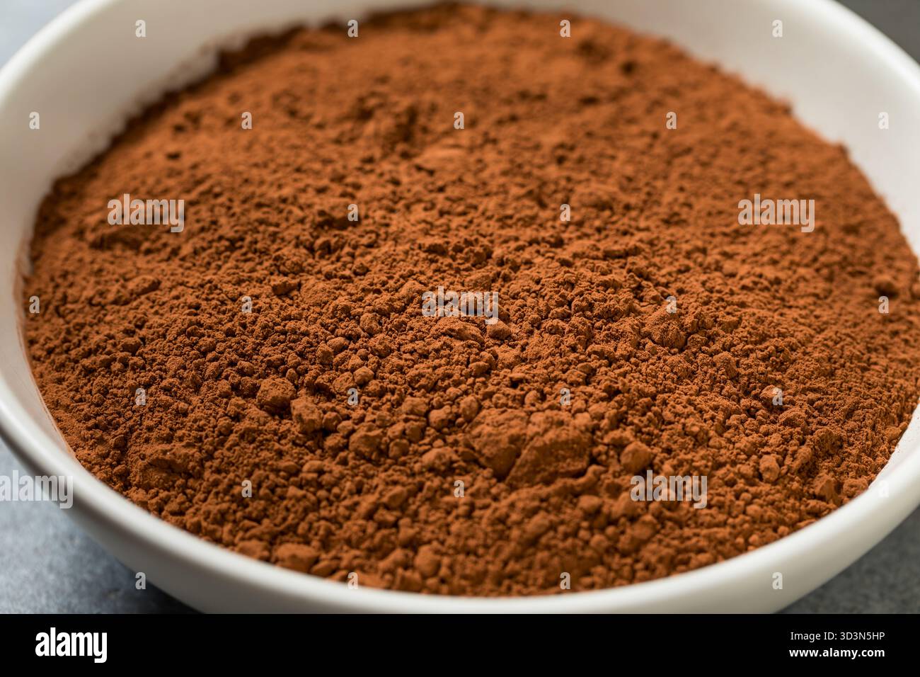 Polvere di cacao secco crudo organico in una ciotola Foto Stock