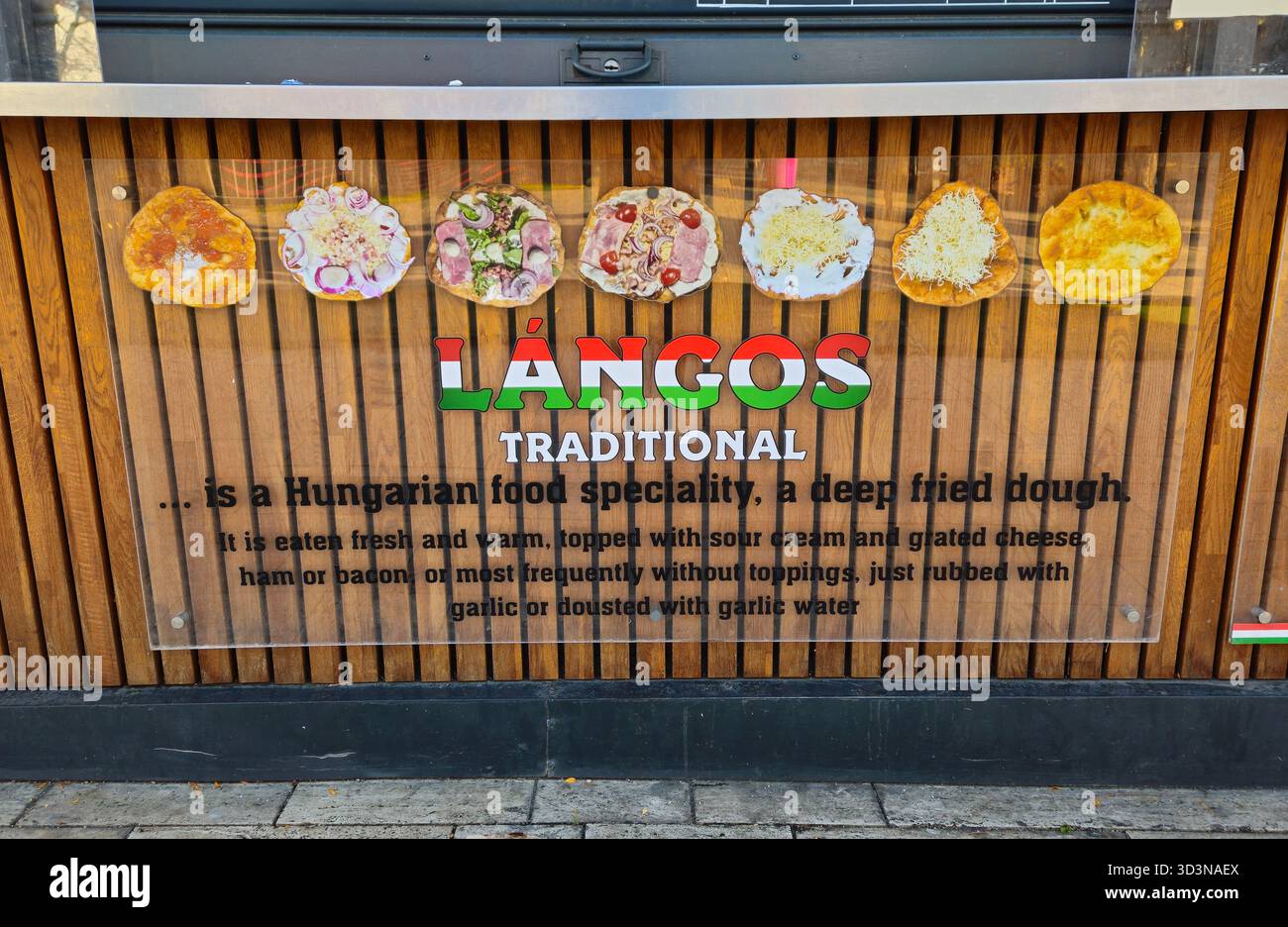 Insegna del cibo di strada all'aperto che descrive lángos, un tradizionale piatto ungherese fritto in profondità con illustrazioni di vari tipi e condimenti Foto Stock