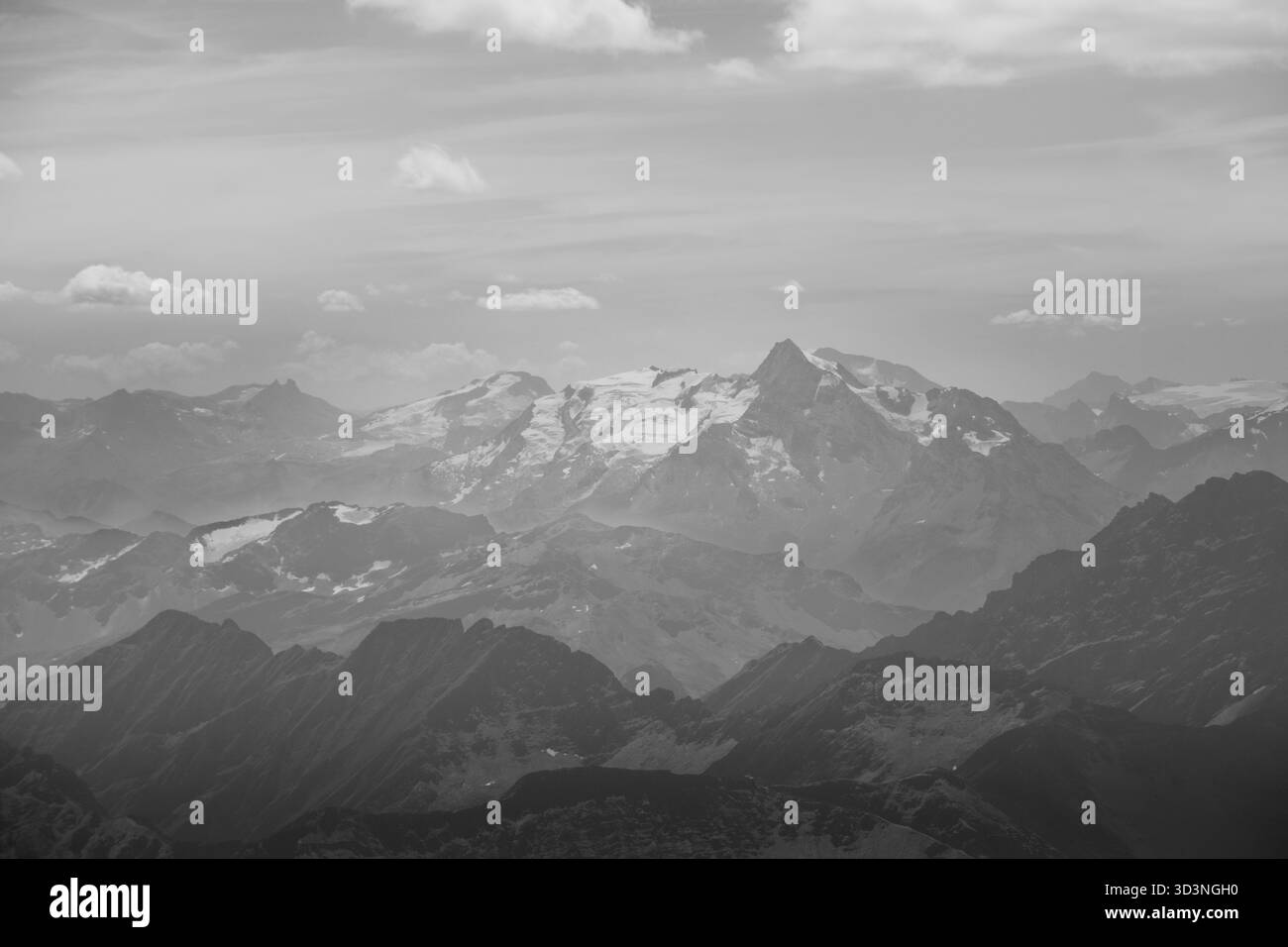 Moody black and white panorama di creste alpine stratificate e lontane cime innevate Foto Stock