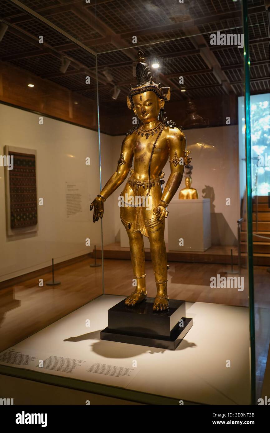 Padmapani, una statua in rame dorato, presenta dettagli intricati con lapislazzuli, gemme e pietre, presentati all'interno di una mostra museale. Foto Stock