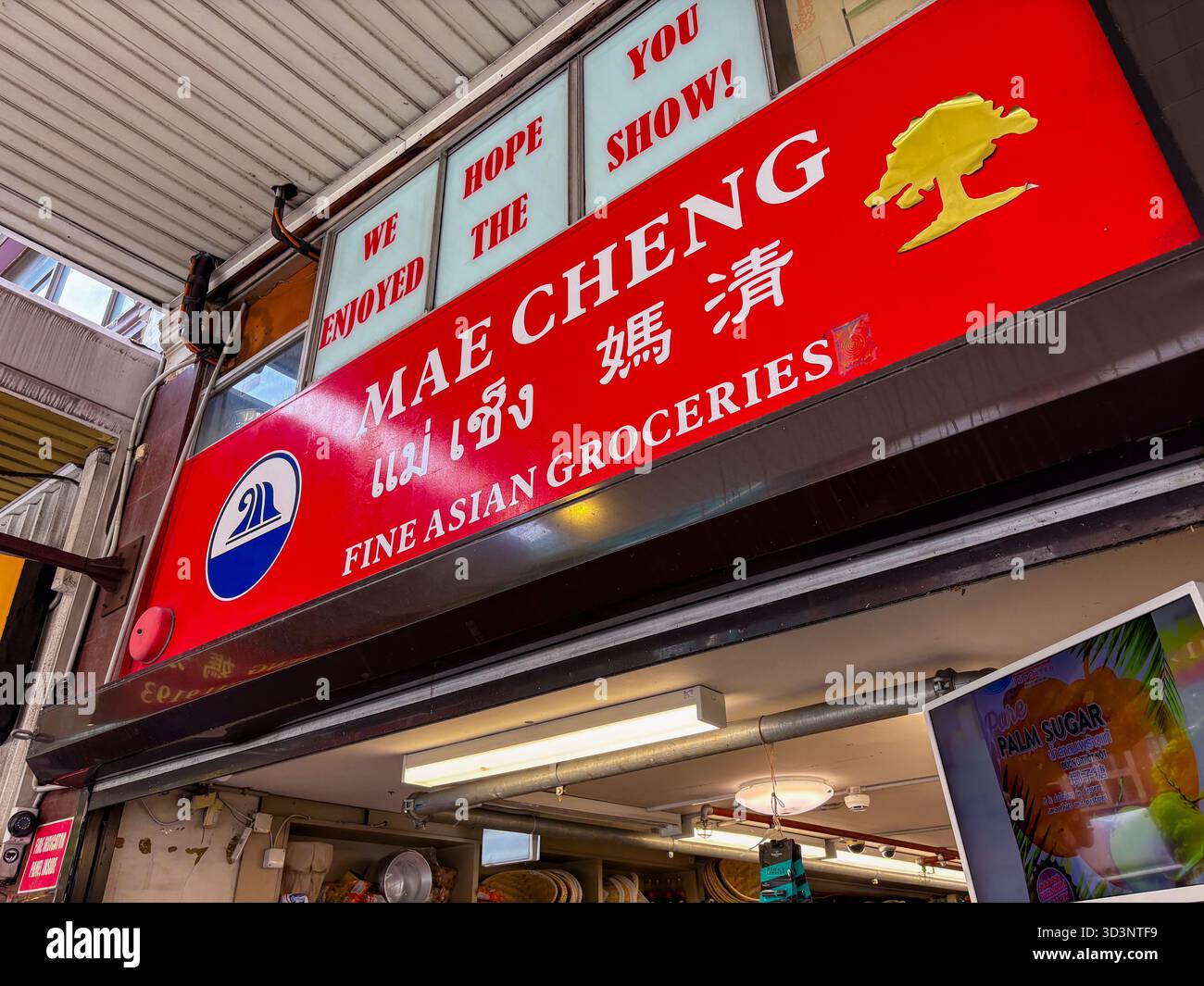 Insegna del negozio di alimentari Mae Cheng fine Asian a Sydney, Australia, che mostra il nome dell'azienda in inglese e tailandese su sfondo rosso con un gol Foto Stock