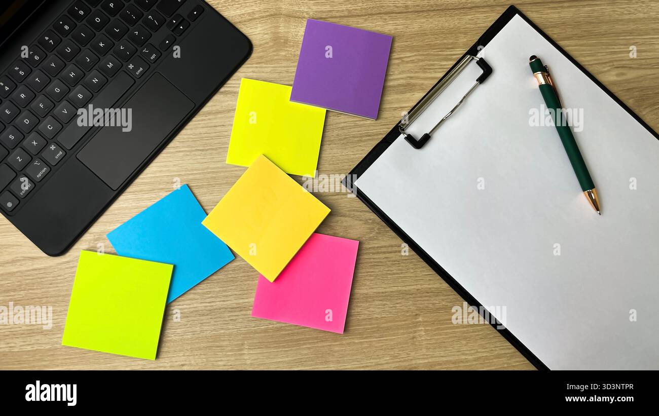 Un'area di lavoro creativa con appunti colorati, un notebook e un foglio di carta vuoto per appunti. Un concetto di produttività e ispirazione. - Immagine stock catturata con smartphone