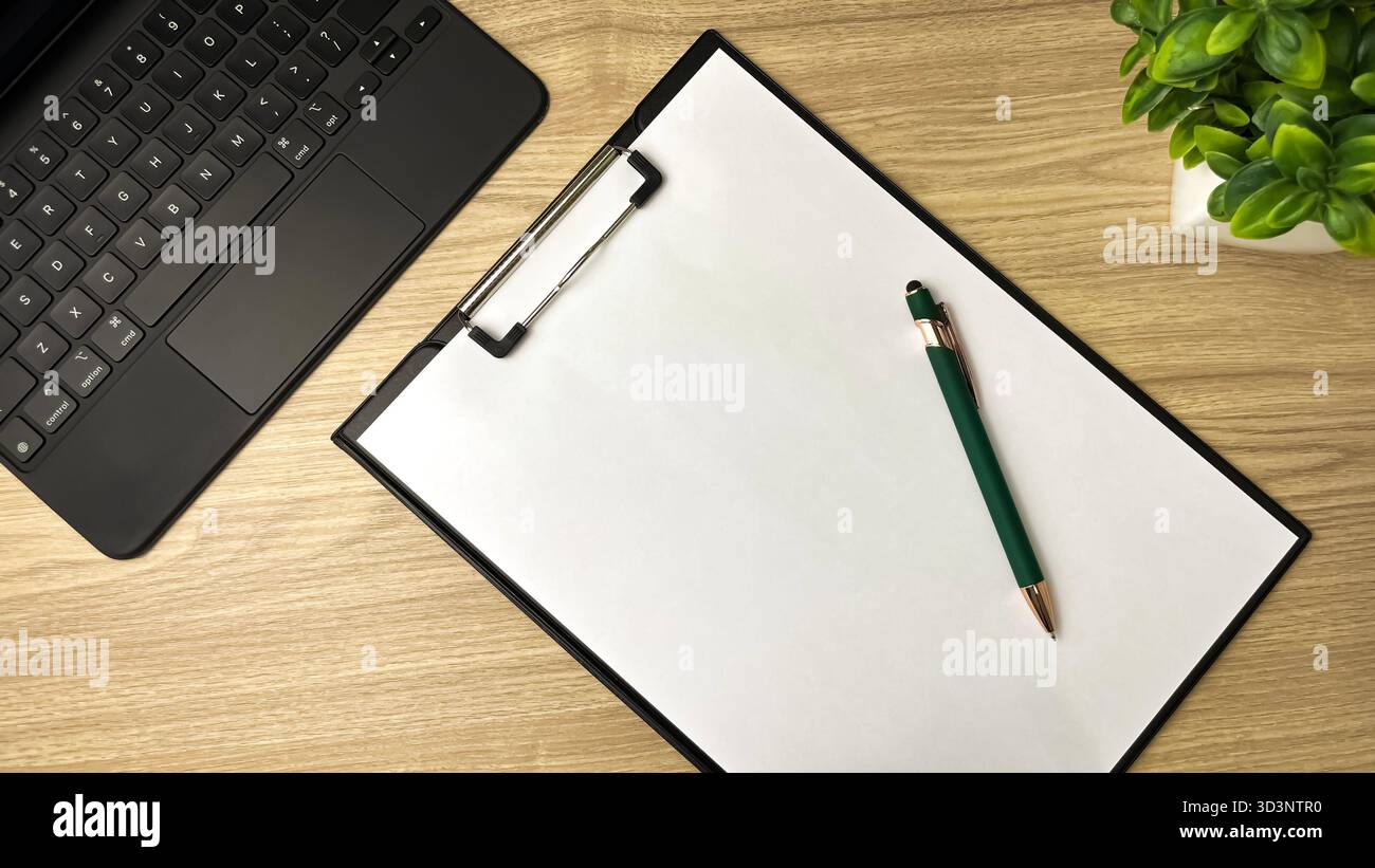 Uno spazio di lavoro minimalista: Un notebook, un foglio di carta vuoto e una penna. Un simbolo di come iniziare, pianificare, idee e produttività. - Immagine stock catturata con smartphone