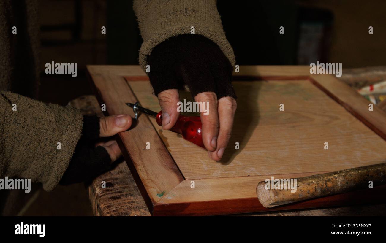 Un tocco intimo di mani che applica la guarnizione di cera utilizzando strumenti e tecniche classici Foto Stock