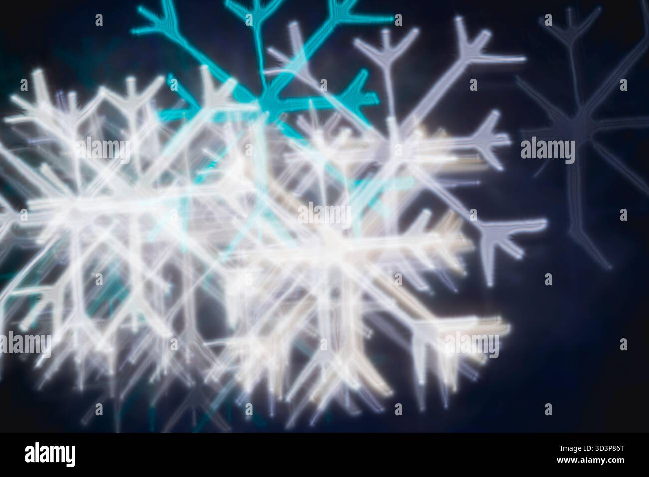 Bokeh bianco e blu turchese con fiocco di neve su sfondo nero: Sfondo astratto per le vacanze invernali, vista frontale. Foto Stock