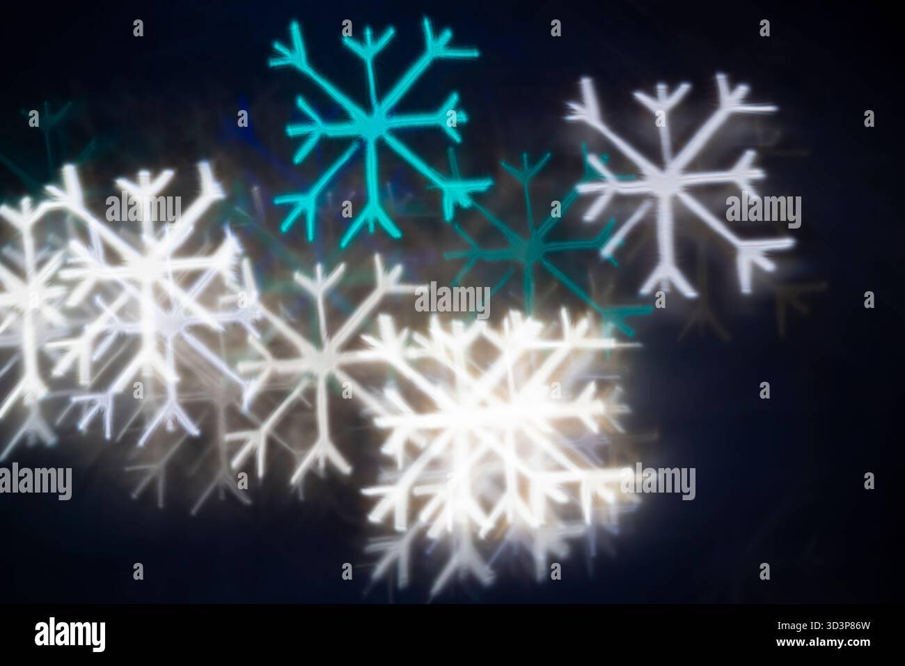 Bokeh bianco e blu turchese con fiocco di neve su sfondo nero: Sfondo astratto per le vacanze invernali, vista frontale. Foto Stock