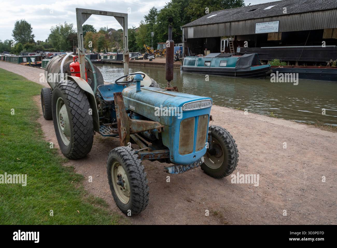 Trattore vintage Fordson Super Dexta che lavora accanto al Grand Union Canal vicino a Braunston, Northamptonshire, Inghilterra Foto Stock