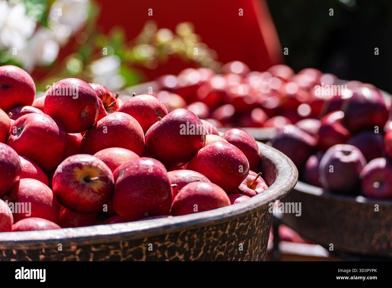 Un vivace mercato di strada con cesti di mele rosse fresche sotto la luce del sole. L'atmosfera vivace mostra l'abbondanza e il fascino di lo Foto Stock