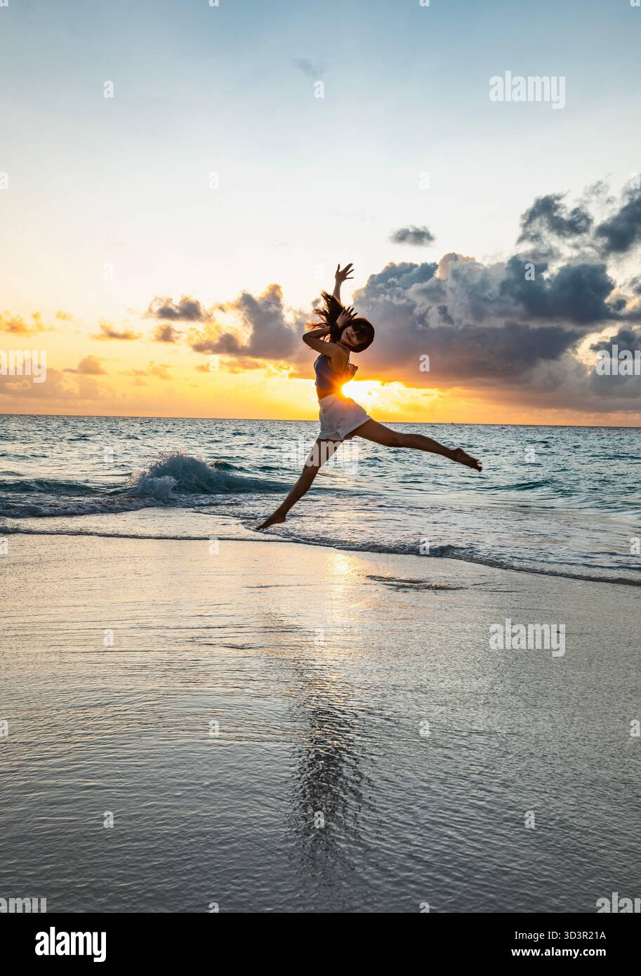 Bella donna che salta su una spiaggia alle Maldive Foto Stock