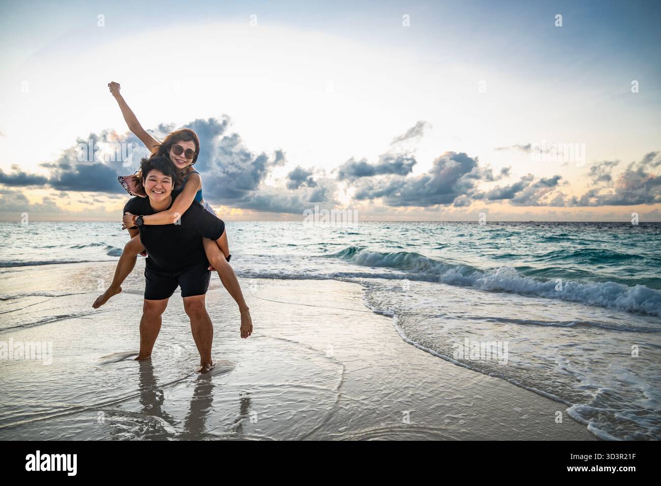 Coppia che si diverte su una spiaggia alle Maldive Foto Stock