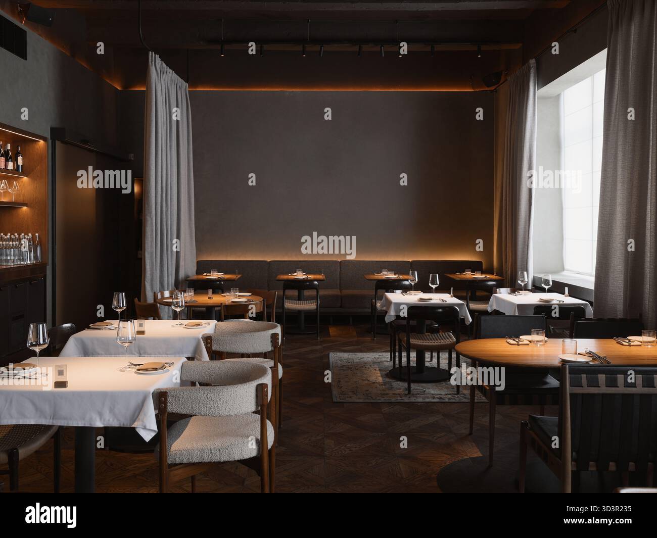 L'accogliente ristorante presenta eleganti tavoli con tovaglie bianche Foto Stock