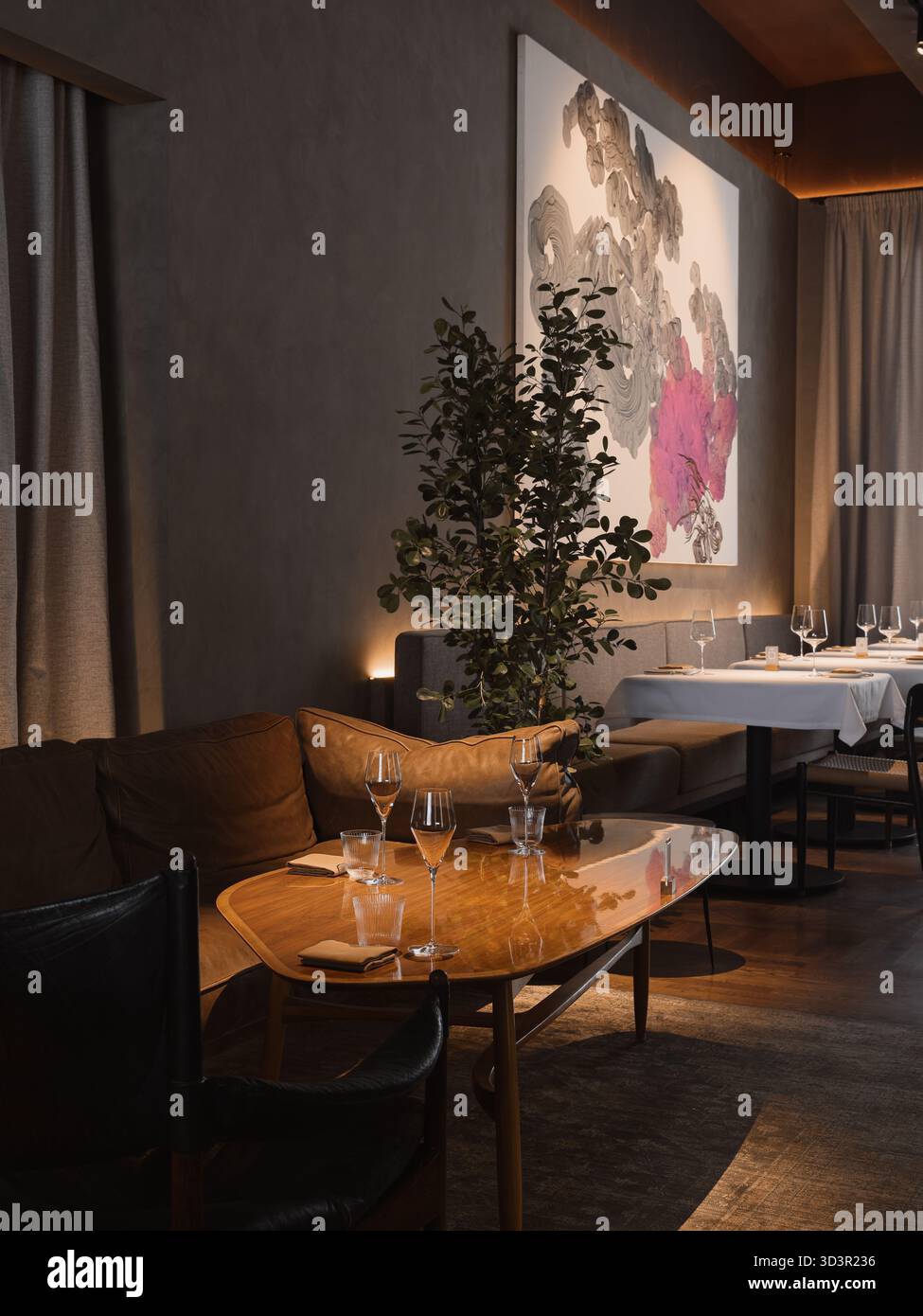 Elegante zona pranzo con arte moderna in un accogliente ambiente ristorante Foto Stock