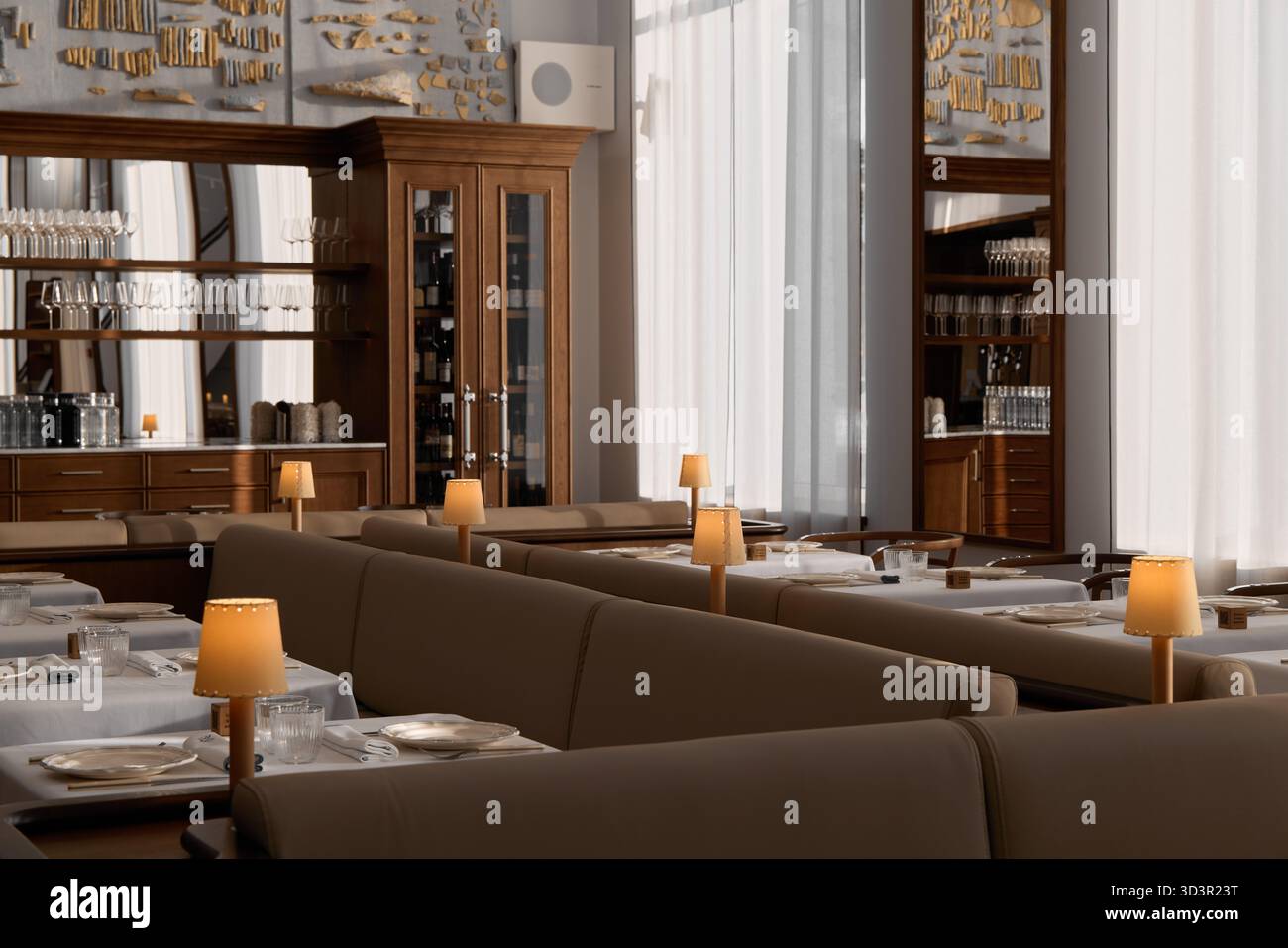 Elegante zona pranzo con illuminazione soffusa in un ristorante moderno Foto Stock