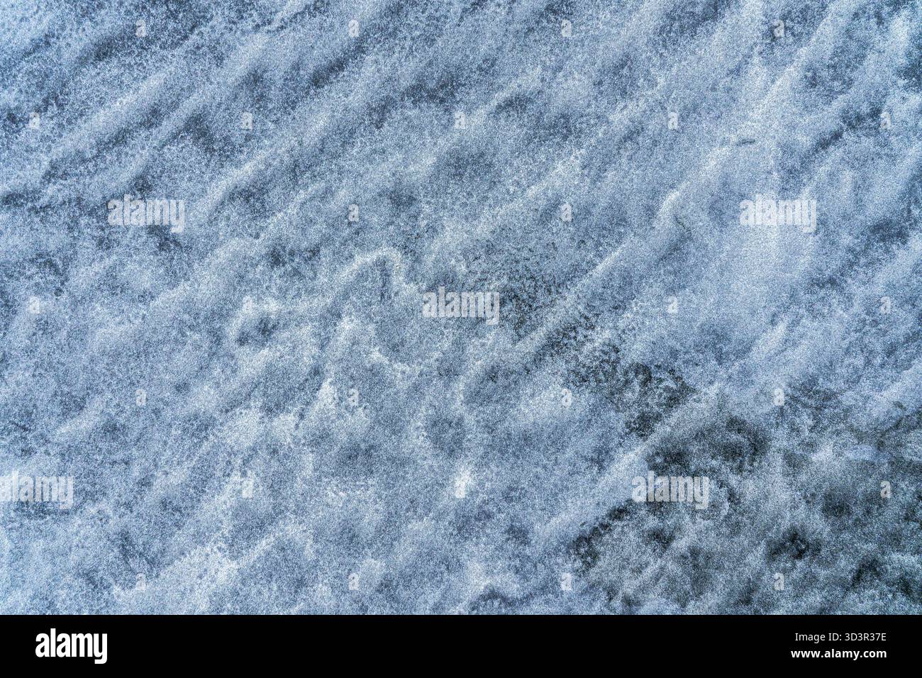 Vista ravvicinata del ghiaccio azzurro ghiacciato, che mostra intricati motivi cristallini che creano una texture naturale e astratta. I toni cool evocano un senso di Foto Stock