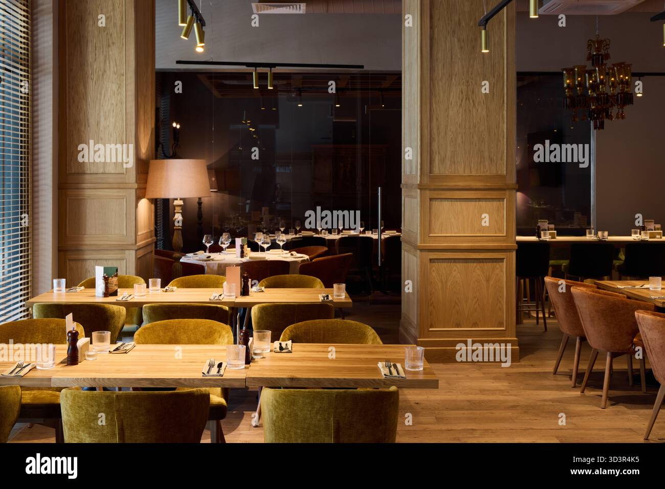 Eleganti interni del ristorante con illuminazione calda e arredi in legno Foto Stock