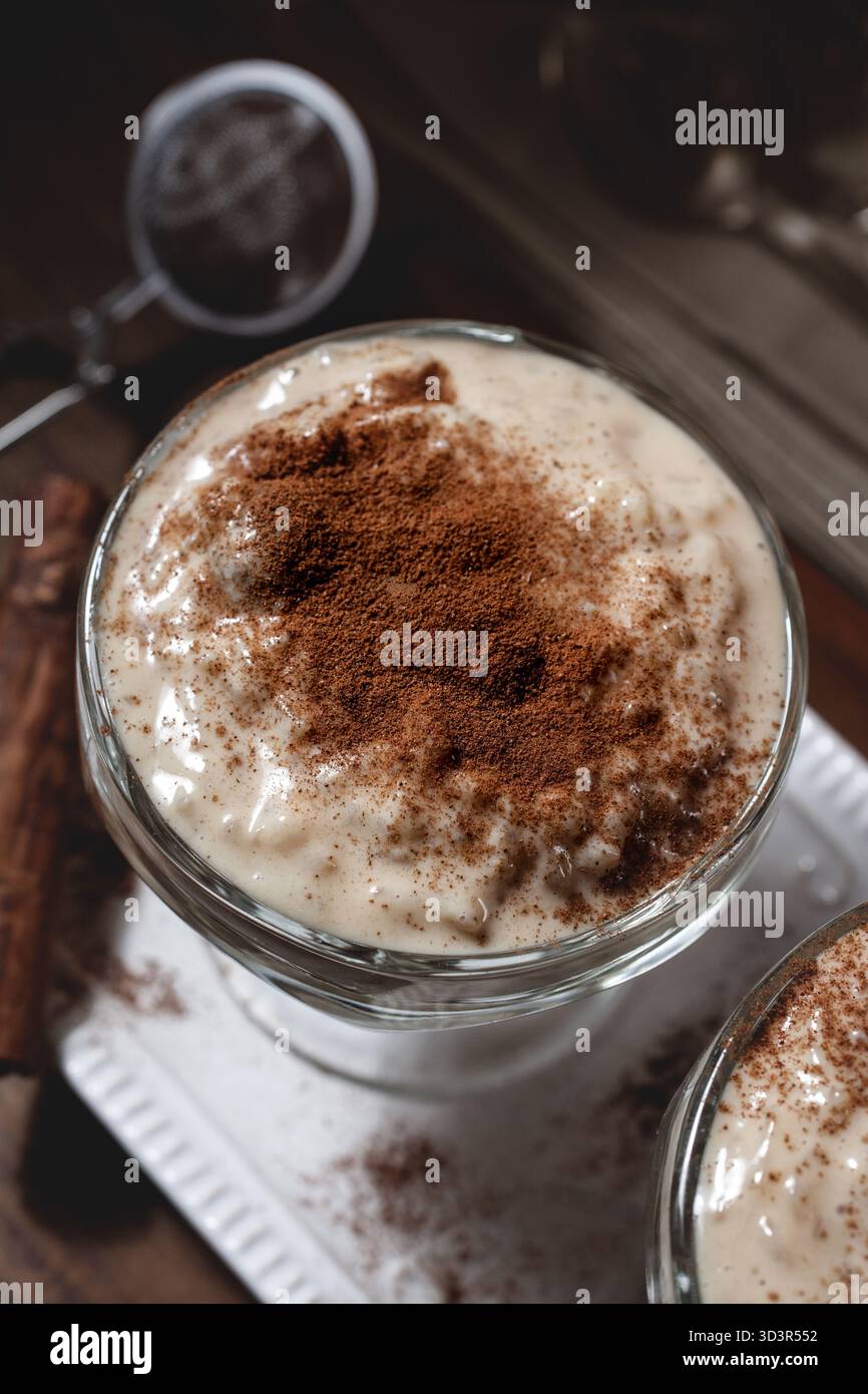 Un budino di riso cremoso fatto in casa, guarnito con fragranti fette di cannella e limone. Un delizioso dessert che offre un sapore caldo e confortante di trad Foto Stock