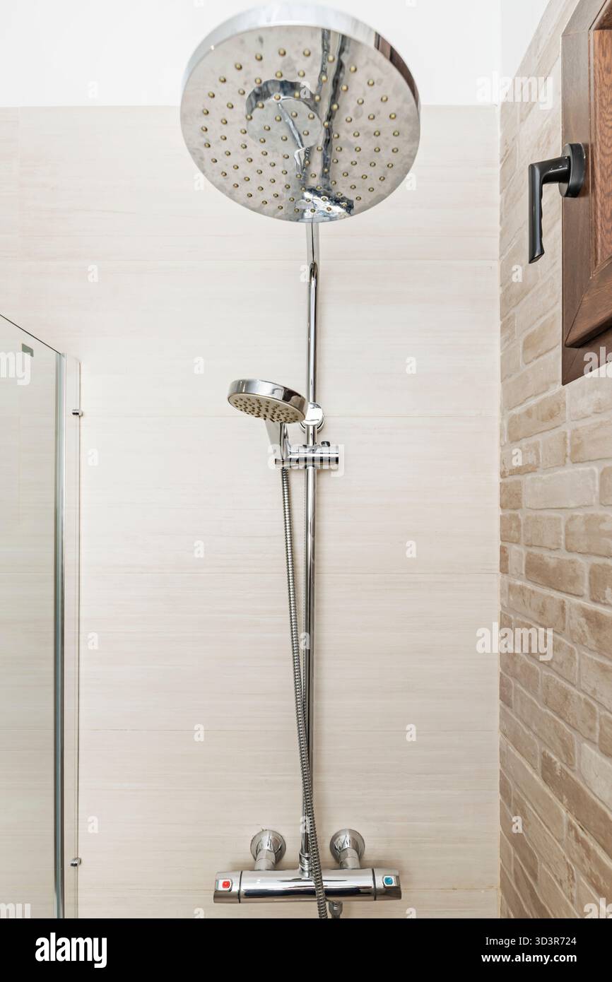 Bagno di lusso con box doccia panoramico, doccia a pioggia tropicale e sistema di vapore integrato nelle pareti in marmo Foto Stock