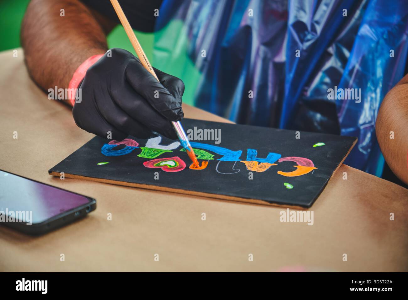 Lima, perù. 01 novembre 2025: persona che indossa un guanto con un pennello per aggiungere colore alle lettere disegnate Foto Stock