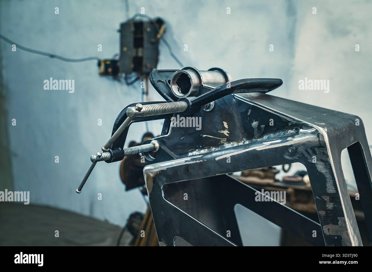 Il morsetto metallico tiene insieme le parti in ferro. Il morsetto è dotato di una vite filettata per il serraggio e la regolazione della pressione. Informazioni generali sulle officine industriali. Foto Stock