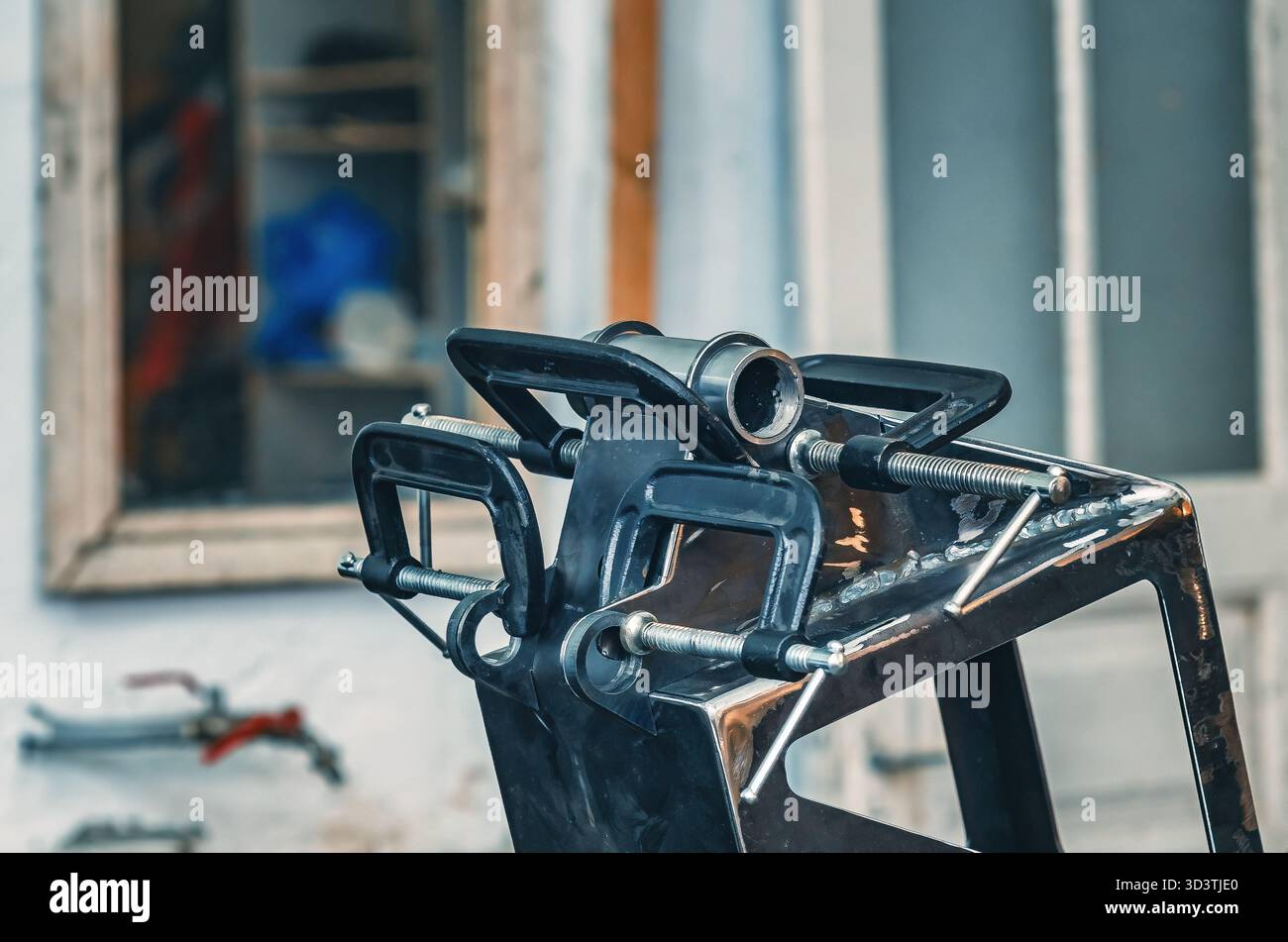 Il morsetto metallico tiene insieme le parti in ferro. Il morsetto è dotato di una vite filettata per il serraggio e la regolazione della pressione. Informazioni generali sulle officine industriali. Foto Stock