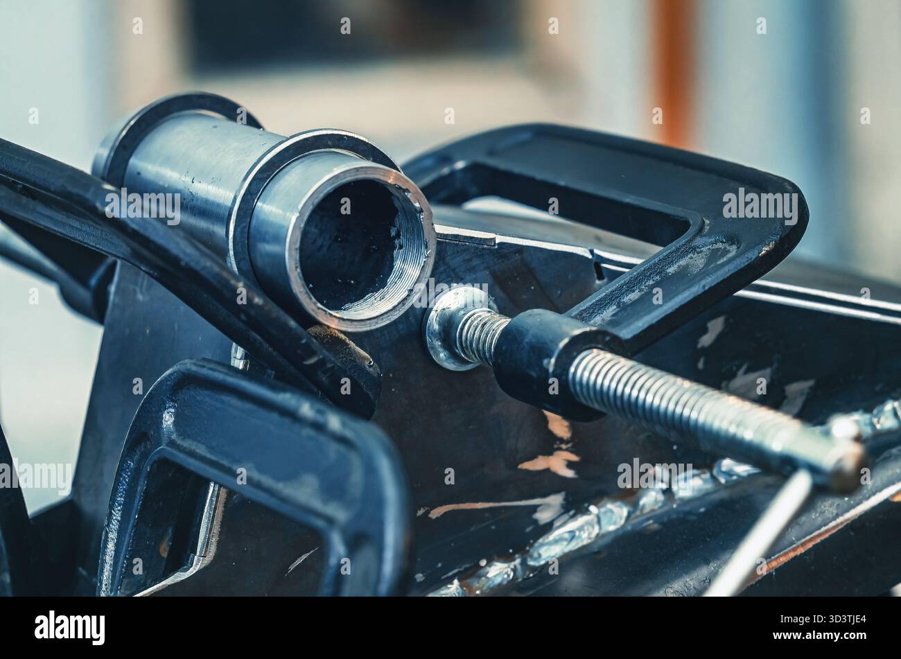 Il morsetto metallico tiene insieme le parti in ferro. Il morsetto è dotato di una vite filettata per il serraggio e la regolazione della pressione. Background industriale. Foto Stock