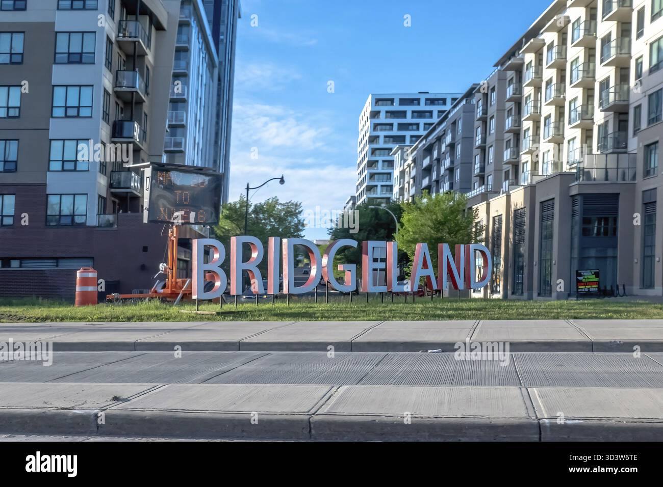 Calgary, Alberta, Canada. 5 giugno 2025. L'audace insegna BRIDGELAND, con moderni edifici di appartamenti sullo sfondo, accoglie residenti e visitatori in una Foto Stock