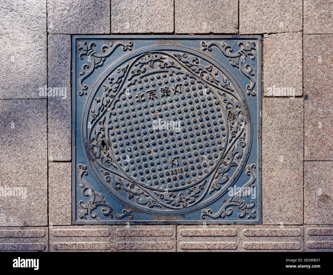 Tombini decorati su un marciapiede di Pechino Foto Stock