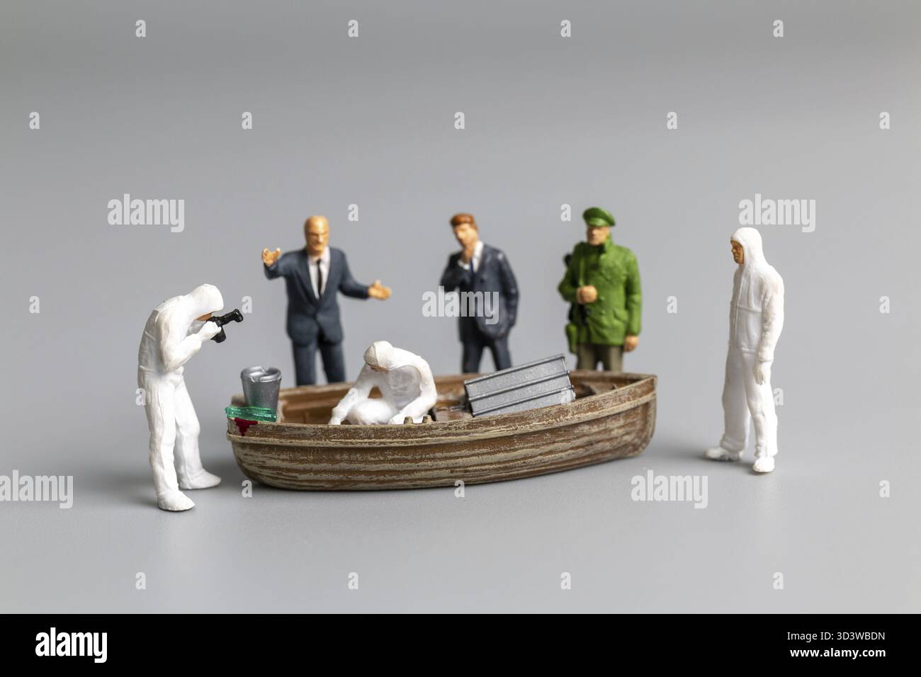 La polizia del popolo in miniatura e il detective stanno lavorando sulla nave, sul concetto di investigazione sulla scena del crimine Foto Stock