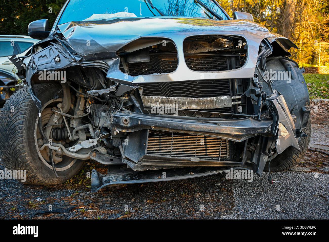 Parte anteriore della vettura gravemente danneggiata che mostra impatto, metallo piegato e radiatore rotto. Foto Stock