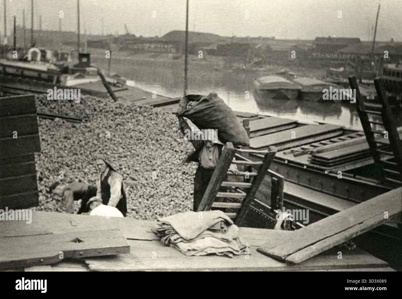 Una foto del 1939 che mostra uomini che scaricano carbone all'Admiraliteitskade e al Boerengat per lo Steenkolen Handels Vereniging nei Paesi Bassi. Questa immagine cattura il commercio di carbone vitale per l'economia durante quel periodo. Foto Stock