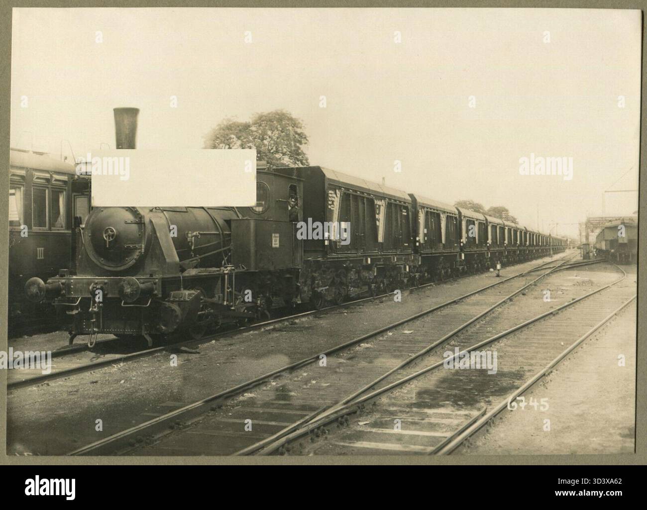 Questa foto probabilmente raffigura una locomotiva o&K Works con nuove auto merci della Reichsbahn, probabilmente scattata dopo l'Anschluss dell'Austria nel 1938. Il pullman sulla sinistra assomiglia a un ex KKStB 'Stadtbahnwagen' o a un pullman simile. Foto Stock