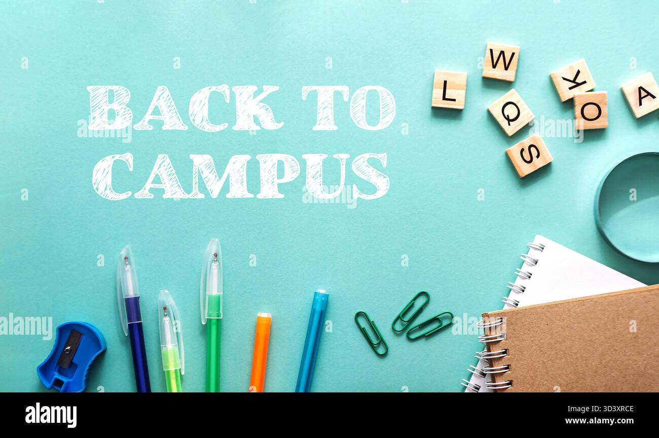 Il ritorno al campus è scritto su uno sfondo blu. Ci sono diversi elementi sul tavolo, tra cui penne, matite e un paio di forbici. Anche il tavolo Foto Stock