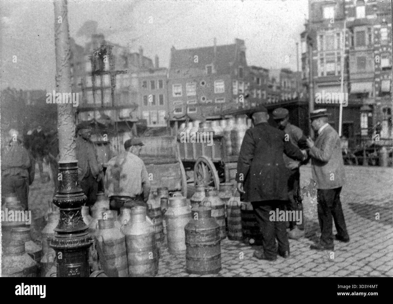 Nel 1911, il latte proveniente dagli agricoltori dell'Olanda settentrionale fu consegnato ad Amsterdam via barca. Il latte è stato scaricato a Prins Hendrikkade da Haarlemmersluis, dove è stato ispezionato e mescolato con acqua. Foto Stock
