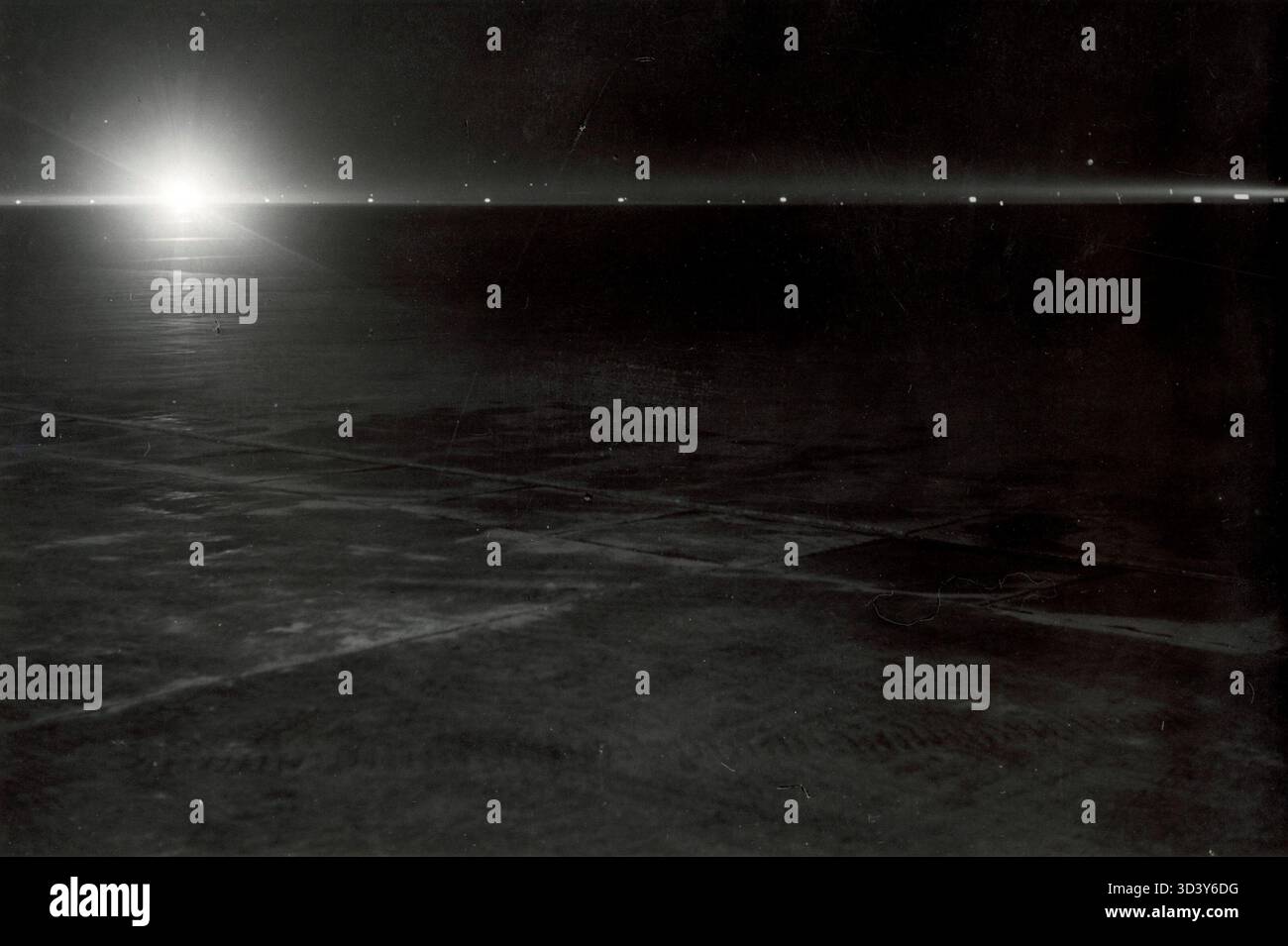 Schiphol Airport di notte nel 1939, caratterizzato da una grande distesa vuota con luci che segnano le piste. La foto cattura l'atmosfera notturna dell'aeroporto e il layout della pista. Foto Stock