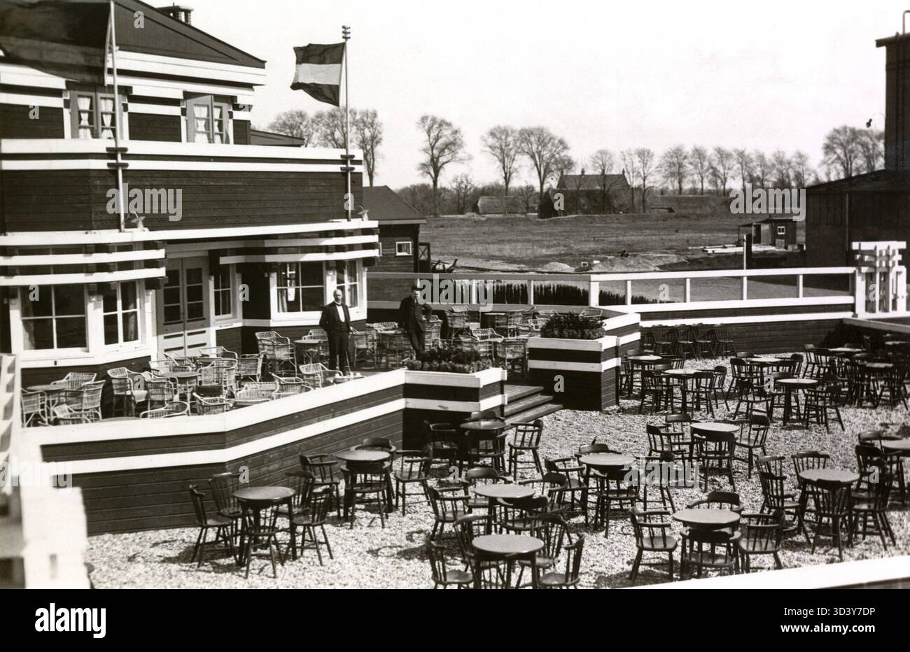 Questa foto del 1922 mostra l'hotel-café-ristorante dell'aeroporto Waalhaven di Rotterdam, Paesi Bassi. Le grandi terrazze offrono una vista del campo d'aviazione, riflettendo i primi giorni dell'aviazione e dei viaggi aerei. Foto Stock