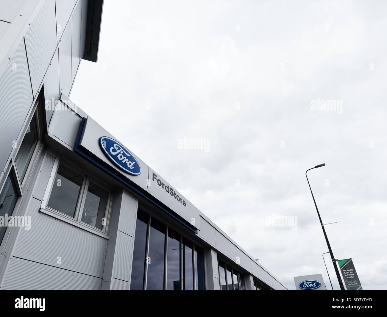 Manchester, Regno Unito - 30 settembre 2025: Vista esterna di un negozio Ford a Manchester, caratterizzato da pannelli eleganti e grandi finestre. Foto Stock
