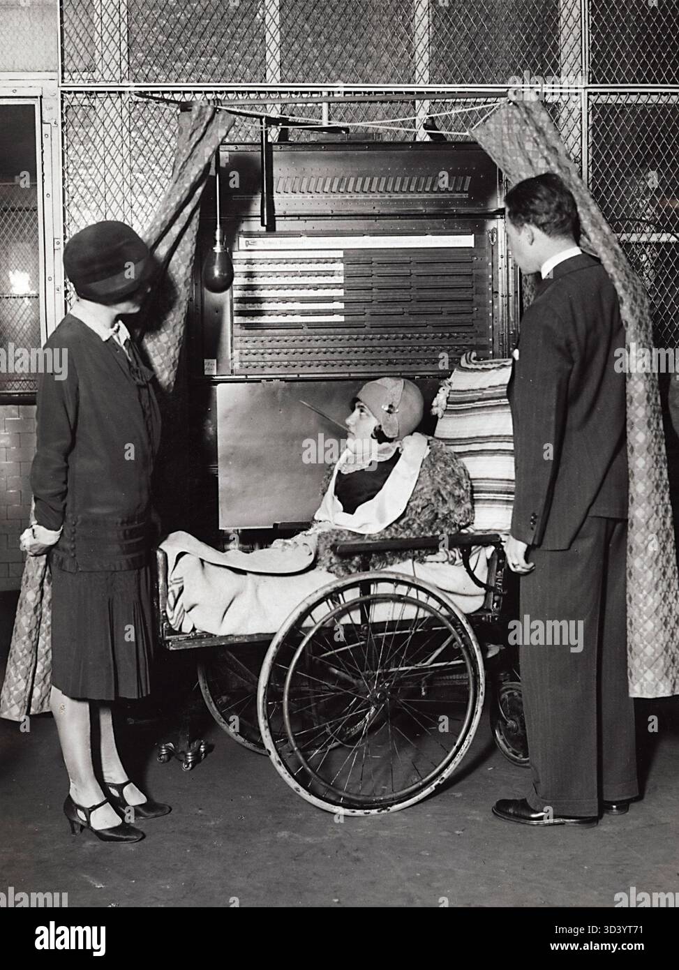 Nel 1928 New York, una donna disabile senza braccia e gambe, seduta su una sedia a rotelle, ha espresso il suo voto alle elezioni presidenziali degli Stati Uniti premendo il pulsante della macchina elettorale con un bastone tenuto in bocca. Foto Stock