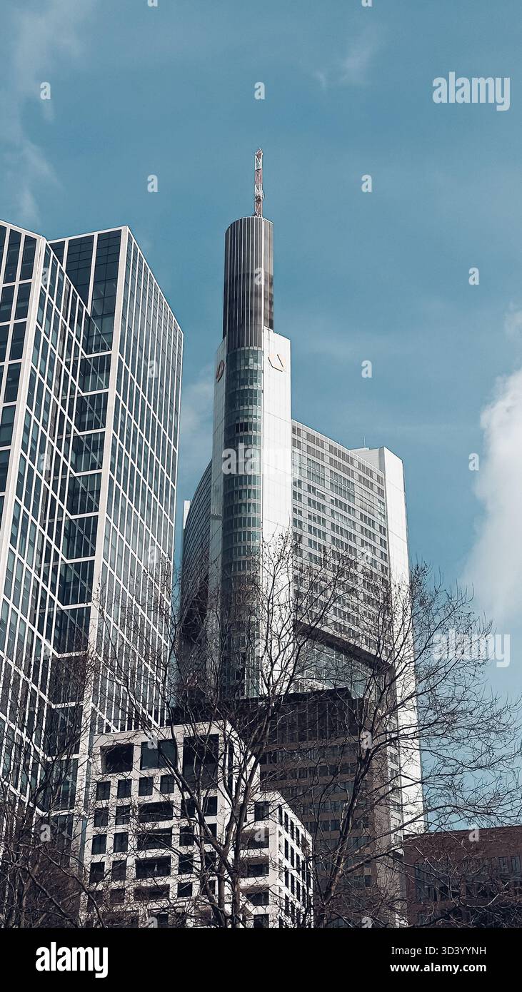 Grattacieli con superfici in vetro riflettente si innalzano contro un cielo blu brillante, evidenziando il design urbano contemporaneo e l'innovazione architettonica Foto Stock