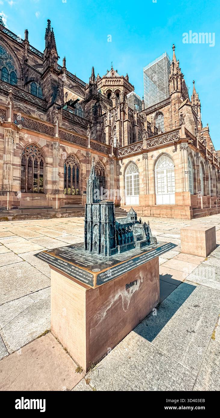 Il dettagliato modello architettonico di una cattedrale storica è esposto in modo prominente in una piazza all'aperto, circondata da intricati lavori in pietra e luce del sole Foto Stock