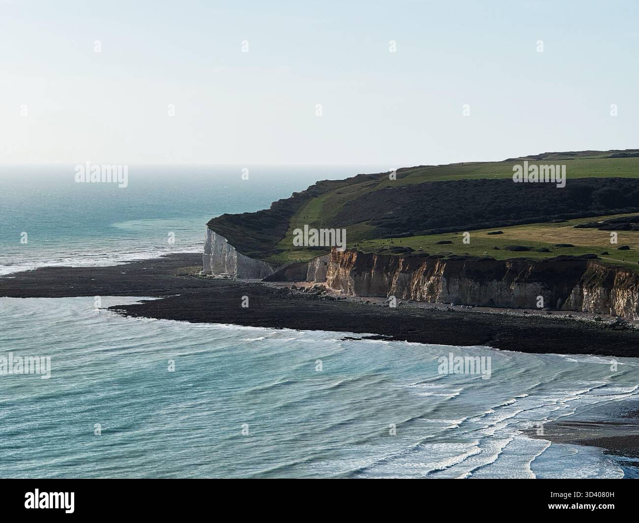 Suggestivo paesaggio costiero con bianche scogliere, campi verdi e mare blu lungo la riva. Foto Stock