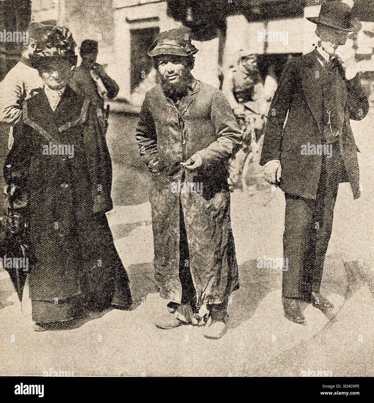 Nel 1915, un uomo e una donna camminano con un uomo scarsamente vestito tra loro in una città occupata dai tedeschi nella Polonia russa. La scena riflette le condizioni dell'occupazione tedesca. Polonia, 1915. Foto Stock