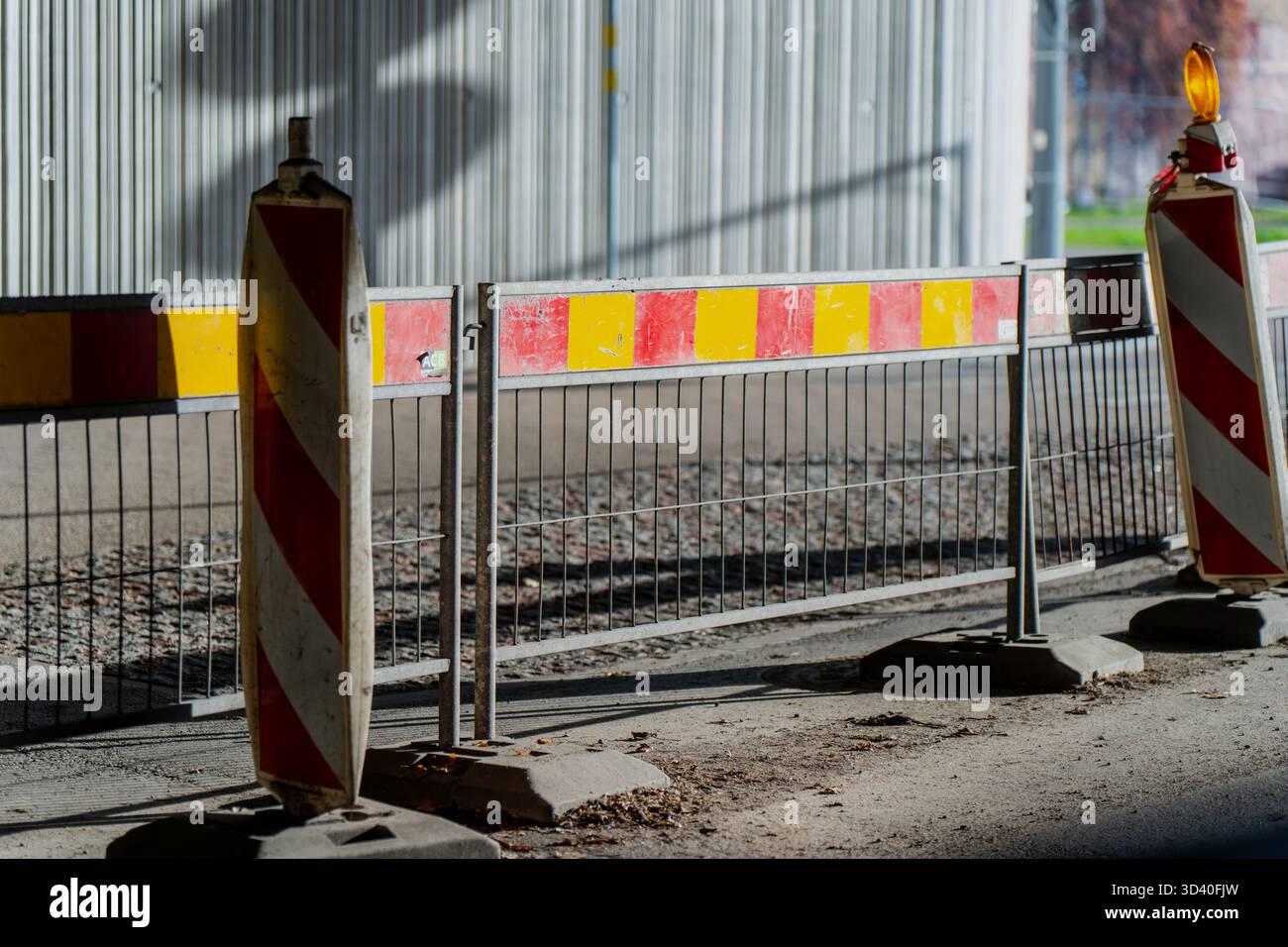 Area di riparazione stradale con pannelli di sicurezza rossi e gialli riflettenti e recinzioni metalliche che rappresentano la manutenzione dell'infrastruttura, la sicurezza del cantiere AN Foto Stock
