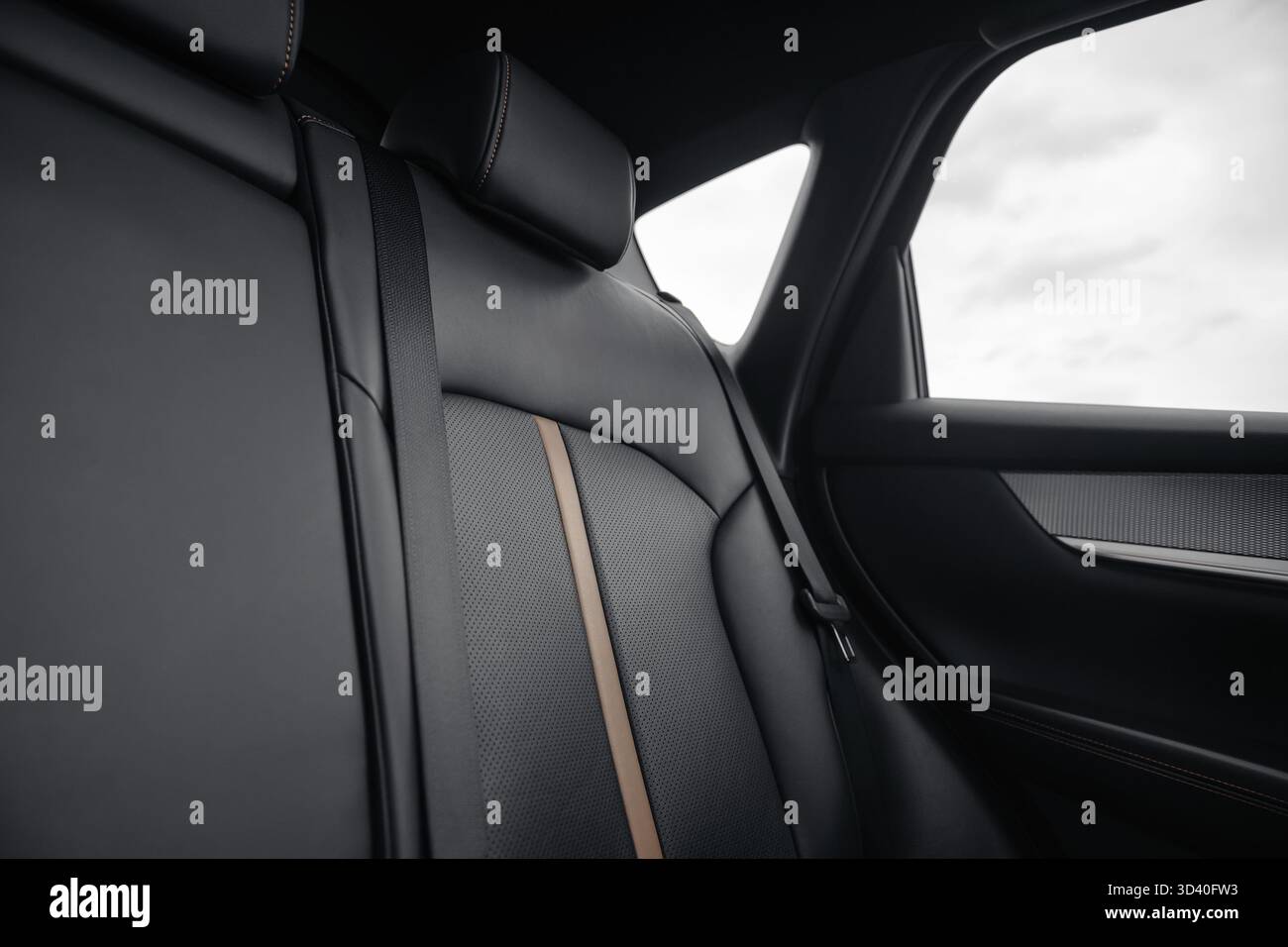 Sedile posteriore in auto - angolo di ripresa basso, grandangolo. Interni SUV o wagon con sedili in pelle nera con inserti traforati e strisce beige. Foto Stock