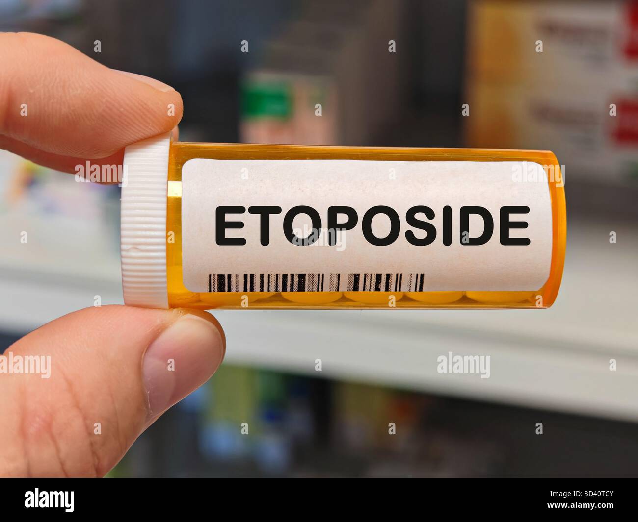 Scatola di plastica arancione di compresse ETOPOSIDE su un tavolo della farmacia ospedaliera usato per trattare i tumori una chemioterapia inibitore della TOPOISOMERASI. Magazzino DELLA FARMACIA Foto Stock