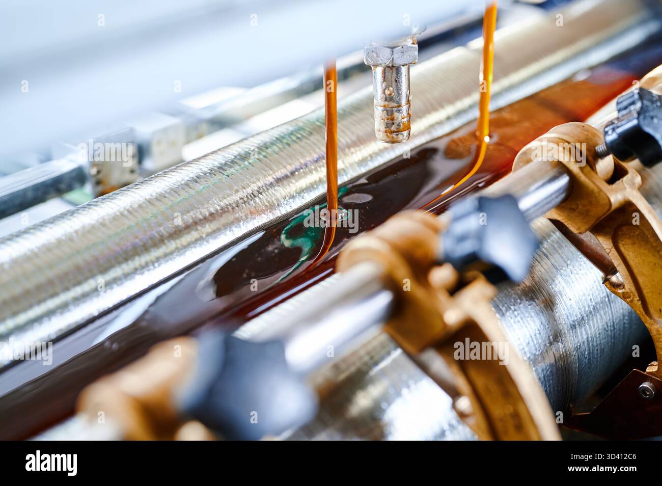 Applicazione di colla di precisione in uno stabilimento di produzione, con tecnologia avanzata di spandimento della colla sul lavoro Foto Stock