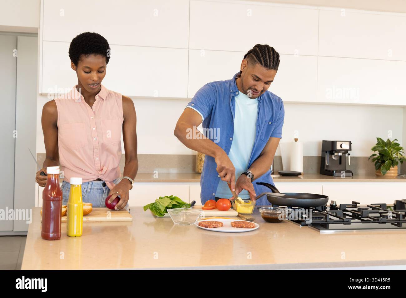 Cucinare diverse coppie di verdure sull'isola della cucina, con taglieri e recipiente per mescolare Foto Stock