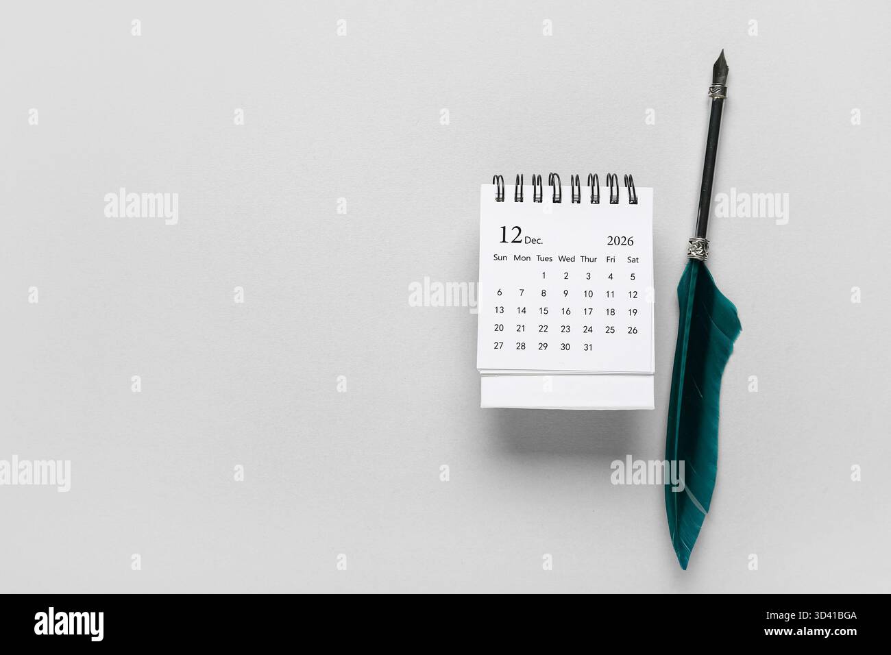 Calendario con piuma su sfondo grigio. Giorno del premio Nobel Foto Stock